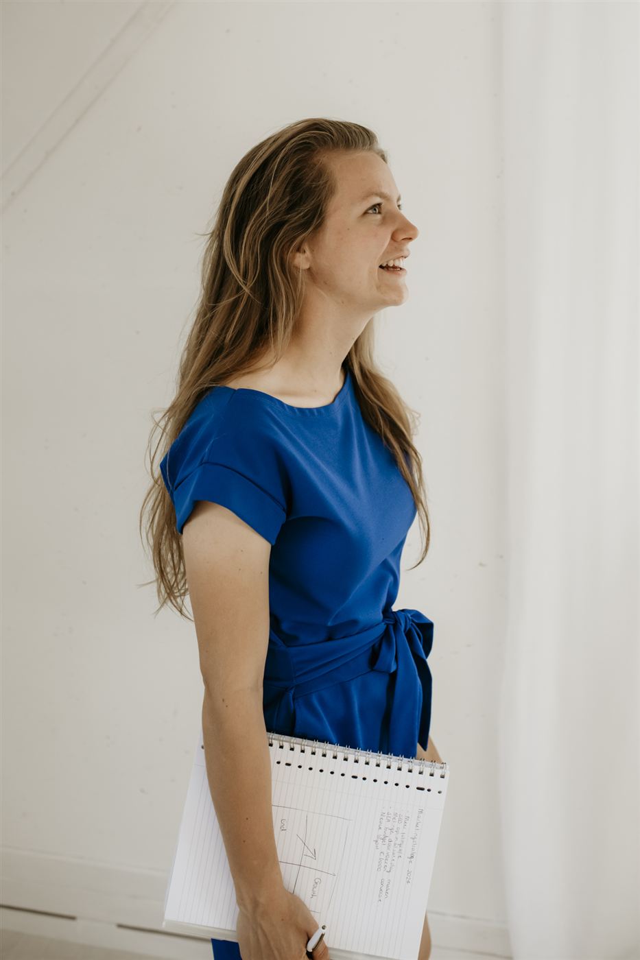 Marije in een blauwe jurk met een notitieblok