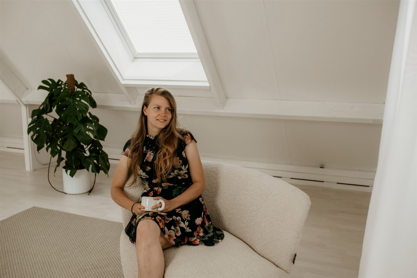 Marije Jongeneel in een fauteuil met een kop thee