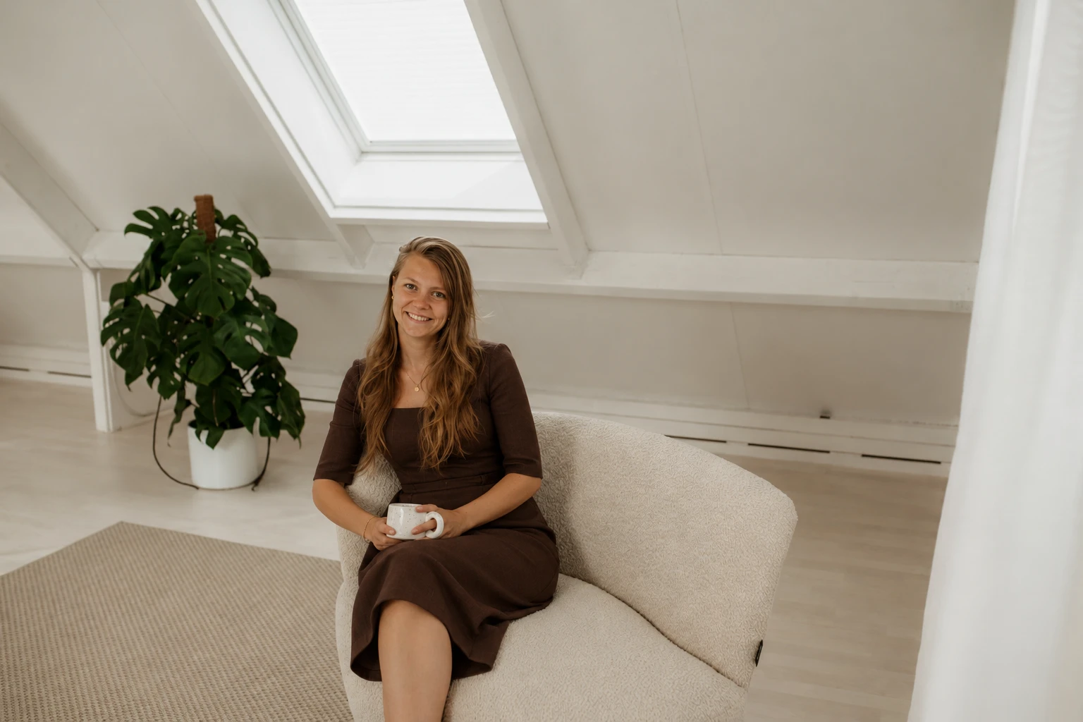 Marije Jongeneel in een fauteuil met een kop thee