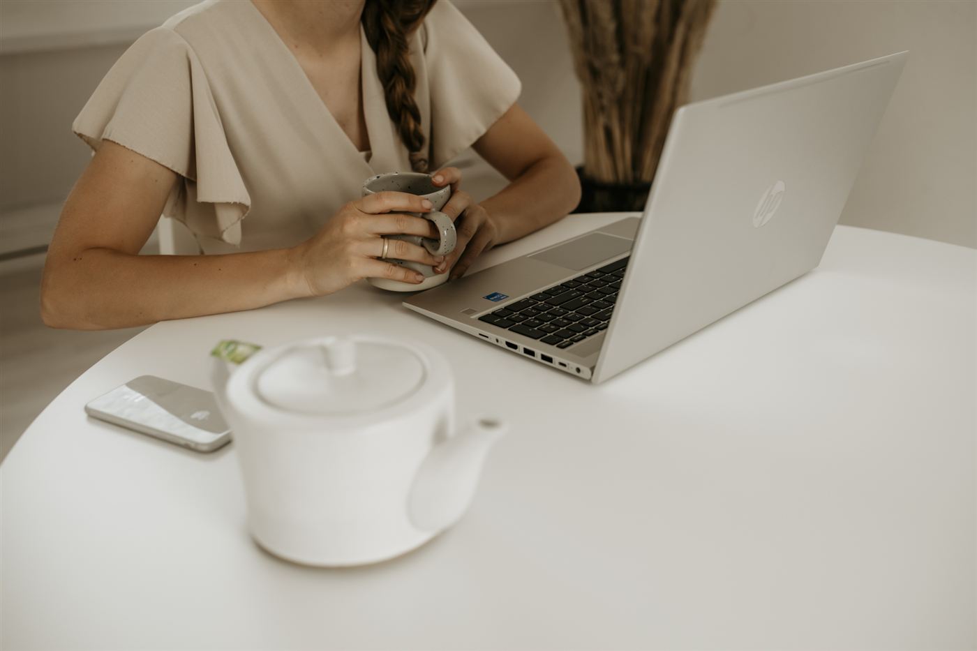 Marije werkt aan haar laptop aan een witte tafel